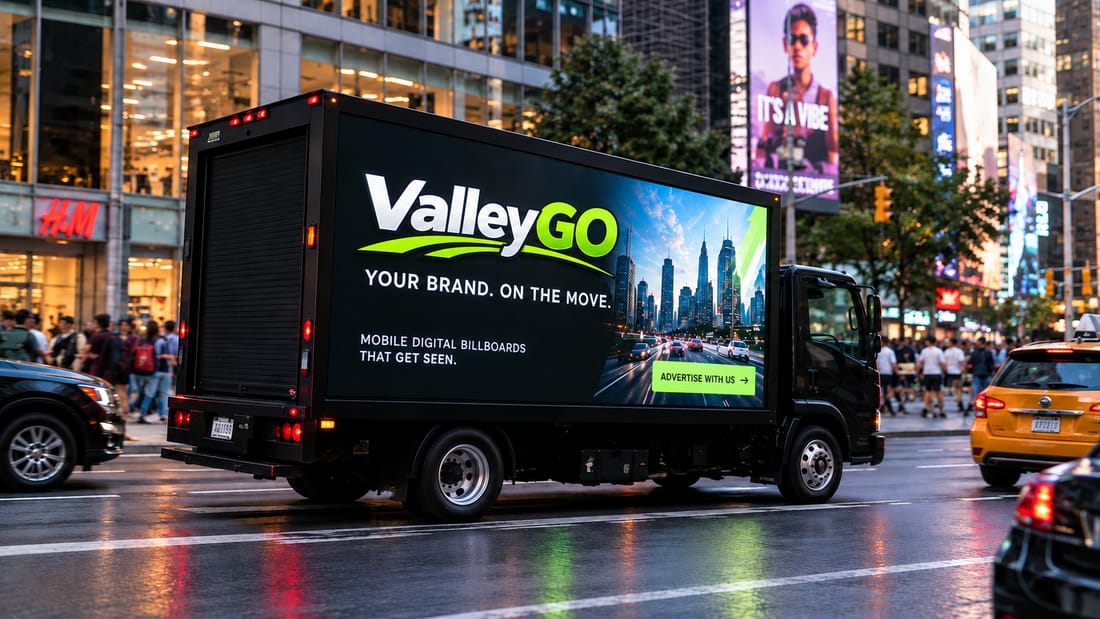 A ValleyGO mobile billboard truck on a busy city street, its LED screen showing a full-colour advert